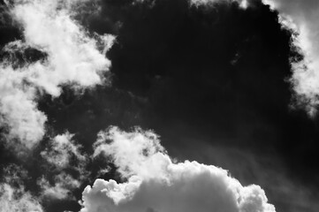 Black and white view on sky with beautiful sunlit clouds