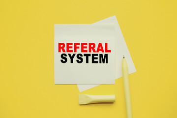 REFERAL SYSTEM. Word on YELLOW sticker with YELLOW pen and yellow background. a bright solution for business, financial, marketing concept