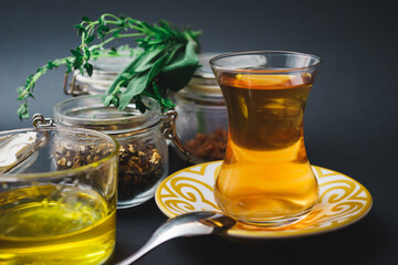 Traditional tea in a glass, tea ceremony with aromatic herbs, mint and honey.