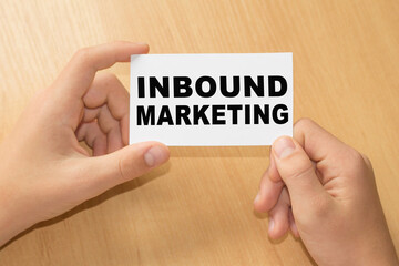 Card with text INBOUND MARKETING on hands. You can use in business, marketing and other concepts. Messege of the day.