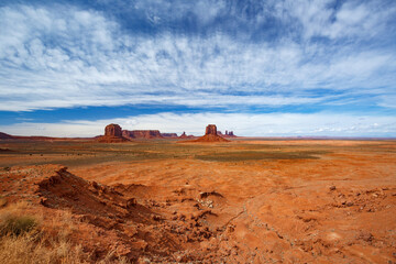 Panoramic view of Monument Valley Navajo Tribal Park landscape. Majestic rock formations under a cloudy blue sky in USA.