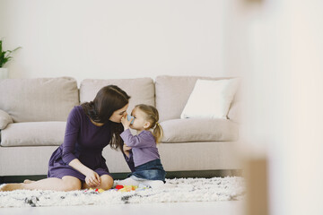 Playful parent mother having fun with child. Mother playing with daughter.