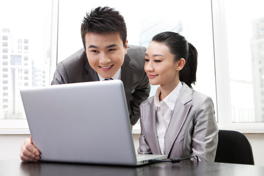 Portrait of Businessman and businesswoman using laptop