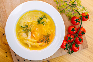 Chicken noodle soup with vegetables on a decorated table