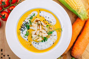 cheese soup with sesame seeds and herbs and vegetables on a decorated table