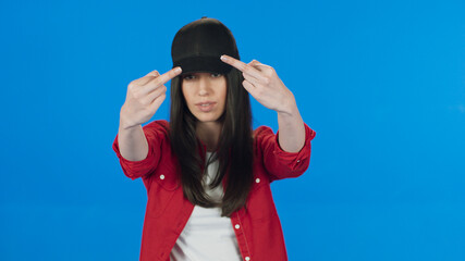 Brunette woman in hat showing middle finger, rude sign of disrespect, making a fuck gesture with...