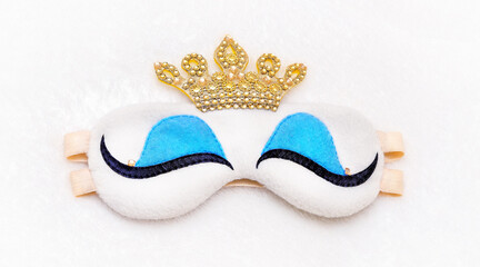 Princess sleep mask on a furry white background with crown