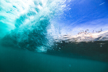 Underwater view from behind breaking wave