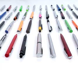 Different pens and colors on a white background