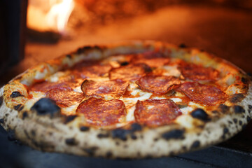 Neapolitan pizza with sausage in a wood-fired oven