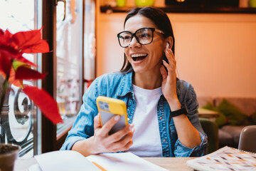 Cheerful woman in glasses and denim jacket talking