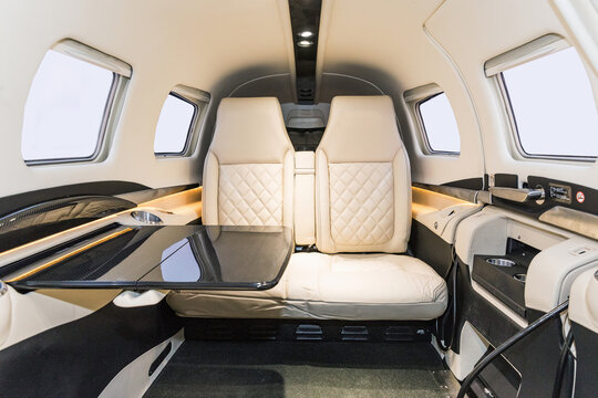 View into the cockpit of a sports plane. A look into the cockpit of a modern sports aircraft. Bright leather seats and a serving table in the cabin.