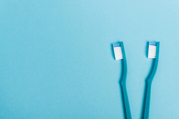 Top view of toothbrushes on blue background with copy space