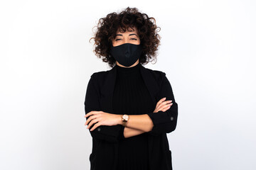 young beautiful caucasian woman wearing medical mask standing against white wall being happy smiling and crossed arms looking confident at the camera. Positive and confident person.