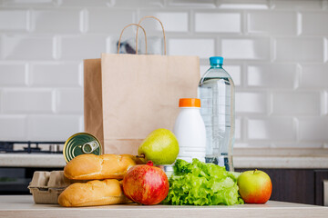 Secure home delivery. A box with various products such as milk, fruit and bread in the kitchen