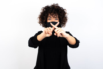 young beautiful caucasian woman wearing medical mask standing against white wall, has rejection...