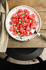 Delicious salad with watermelon served on wooden table indoors, flat lay