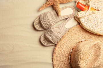 Different beach accessories on sand, flat lay. Space for text
