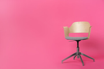 Comfortable office chair on pink background, space for text