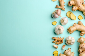 Ginger and garlic on turquoise table, flat lay with space for text. Natural cold remedies