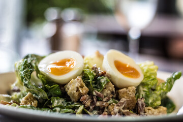 Classic Fresh Caesar Salad with cos lettuce, bacon, garlic croutons, hard boiled egg, Caesar dressing, parmesan cheese