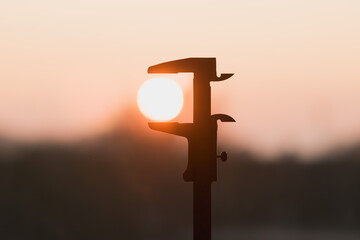 Metal vernier caliper and sunset