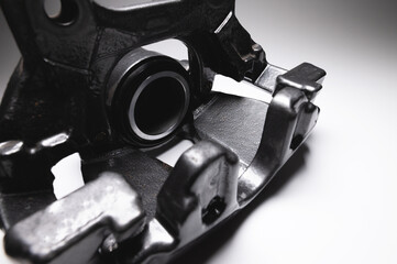 New Brake caliper in black. A spare part for a car brake system on a gray background in high contrast.