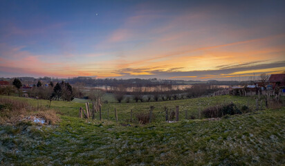 Fototapeta premium a panoramic shot of a landscape with lake in the sunset
