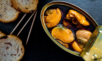 Pickled mussels on a piece of toasted bread with blueberries