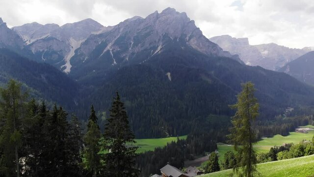 Vista a&eacute;rea del paisaje con monta&ntilde;as rodeadas de &aacute;reas verdes y grandes &aacute;rboles.