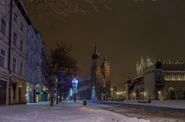 Fototapeta na wymiar Winter in Cracow, snowy night near St. Mary's Church in Cracow marketplace
