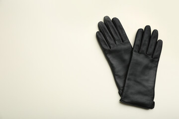 Pair of stylish leather gloves on beige background, flat lay. Space for text