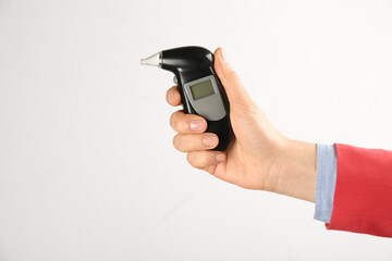 Woman holding modern breathalyzer on white background, closeup