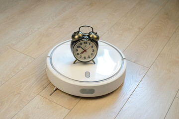 The robot vacuum cleaner is carrying an alarm clock.