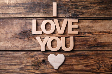 Phrase I Love You and heart on wooden background, flat lay