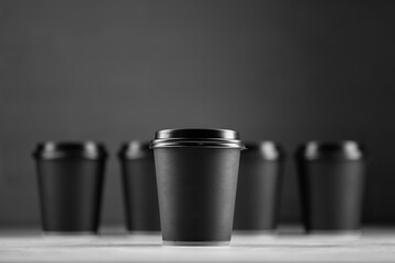 Paper cup of coffee on black background
