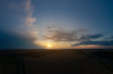Fototapeta na wymiar View from drone, panorama orange sky and gray clouds, sun at sunset