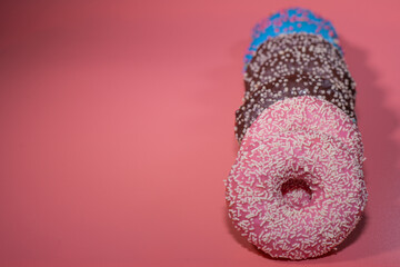 Sweet delicious donuts on a pink background