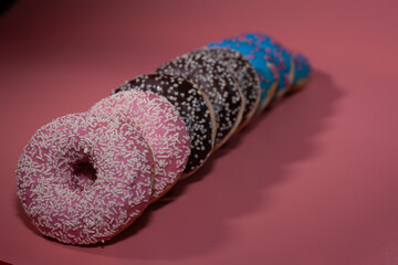 Sweet delicious donuts on a pink background