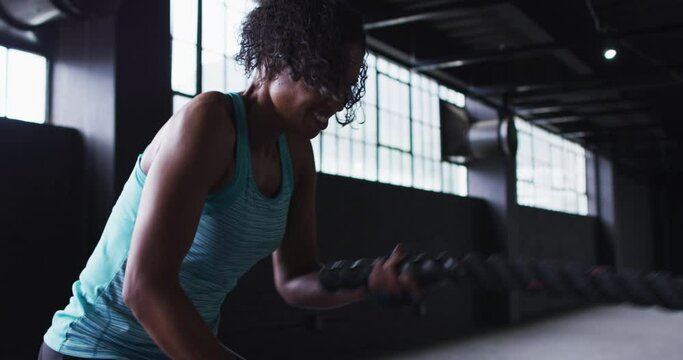 African american woman exercising battling ropes in an empty urban building