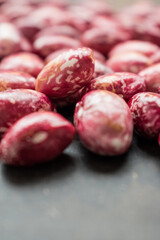 Close up of some raw red beans on a black table 