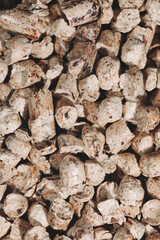 A bunch of wood pellets for heating industrial boilers with solid fuel boilers. Background vertical macro image of biomass pellets close-up. Eco-friendly and low cost fuel concept