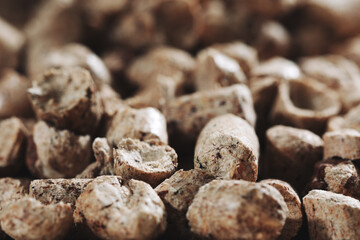 A bunch of wood pellets for heating industrial boilers with solid fuel boilers. Background vertical macro image of biomass pellets close-up. Eco-friendly and low cost fuel concept
