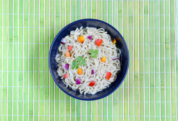 Pasta with vegetables in bowl, top view