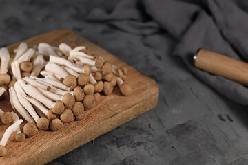 Brown edible mushrooms native to East Asia called 'Buna Shimeji' on wooden cutting board 