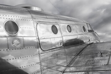 Shiny metal fuselage of a classic, stylish historic airplane in black and white