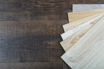 Vinyl and linoleum samples on a wooden background. Vinyl for flooring with wood grain texture and...