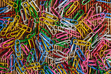 Paper clips scattered on a wooden table.