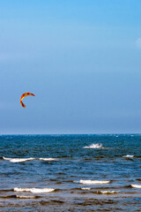 A young man is engaged in extreme kiteboarding in the Gulf of Riga on October 21, 2019 at Cape Kolka in Latvia.