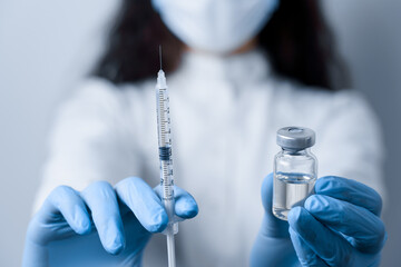 Doctor holding coronavirus vaccine. Covid-19 Vaccination. Stop quarantine. Close-up suringe and...